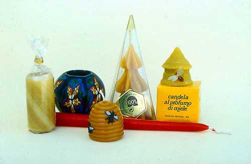 Various shaped candles and packaging. A dipped candle is laying on the bottom.