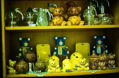 A display of various decorative honey containers and dispensers.