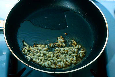 Frying bee larvae in oil.