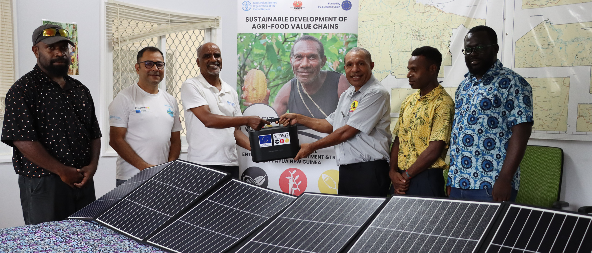 FAO officials or the EU-STREIT PNG Programme, handing over the first Portable Solar Power Generator to the representative of the Women's Micro Bank - Mama Bank in the Sepik region.