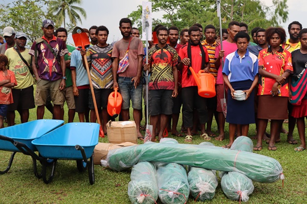 Community members and school's students receiving agriculture production equipment from the EU-STREIT PNG Team