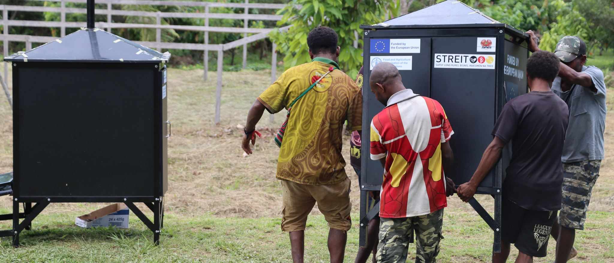 Vanilla farmers from the Sepik region of Papua New Guinea carry a solar dryer provided by the FAO, under the EU-STREIT PNG Programme. ©FAO-STREIT