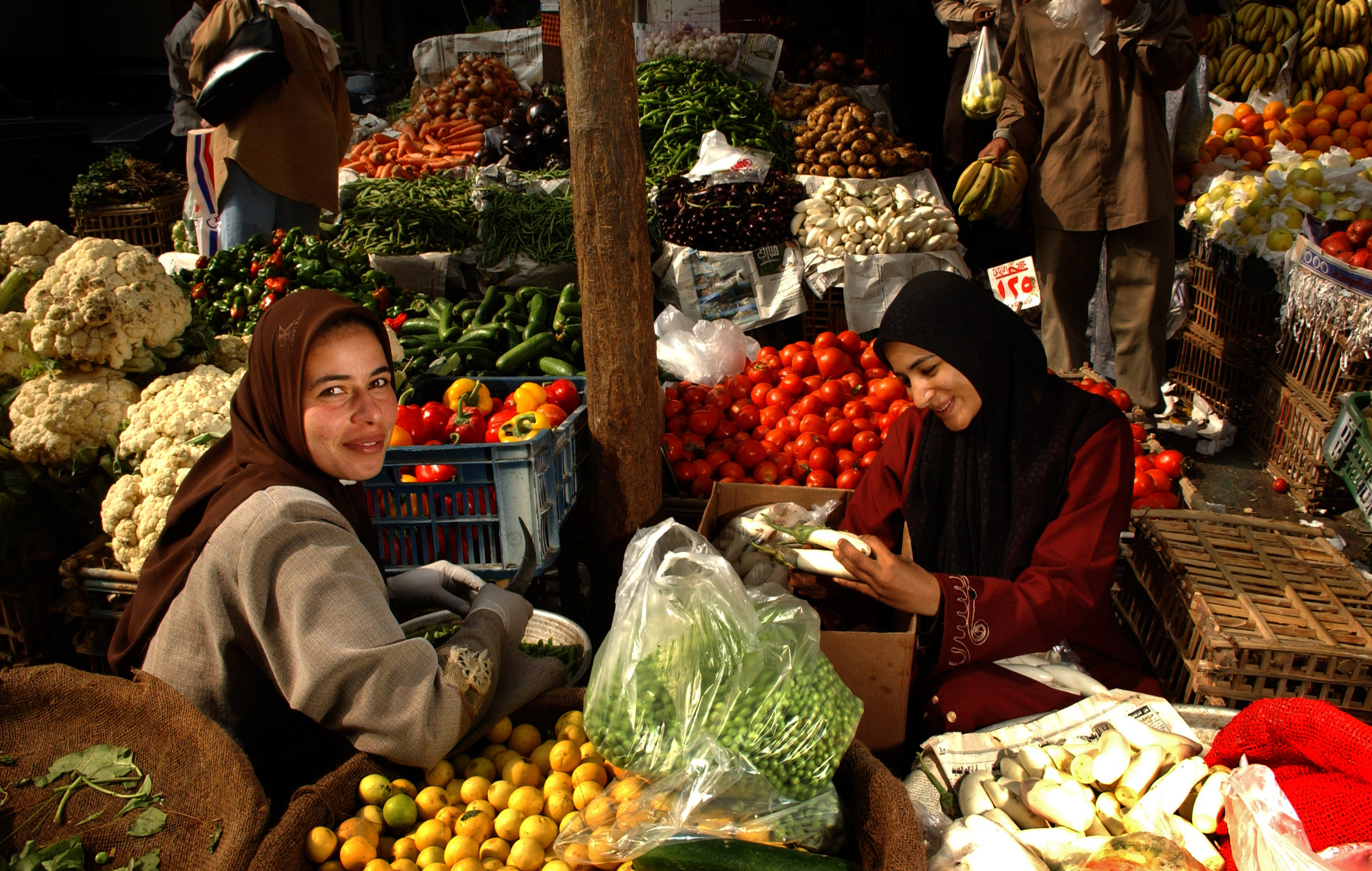 Two women at a market selling fresh produce
