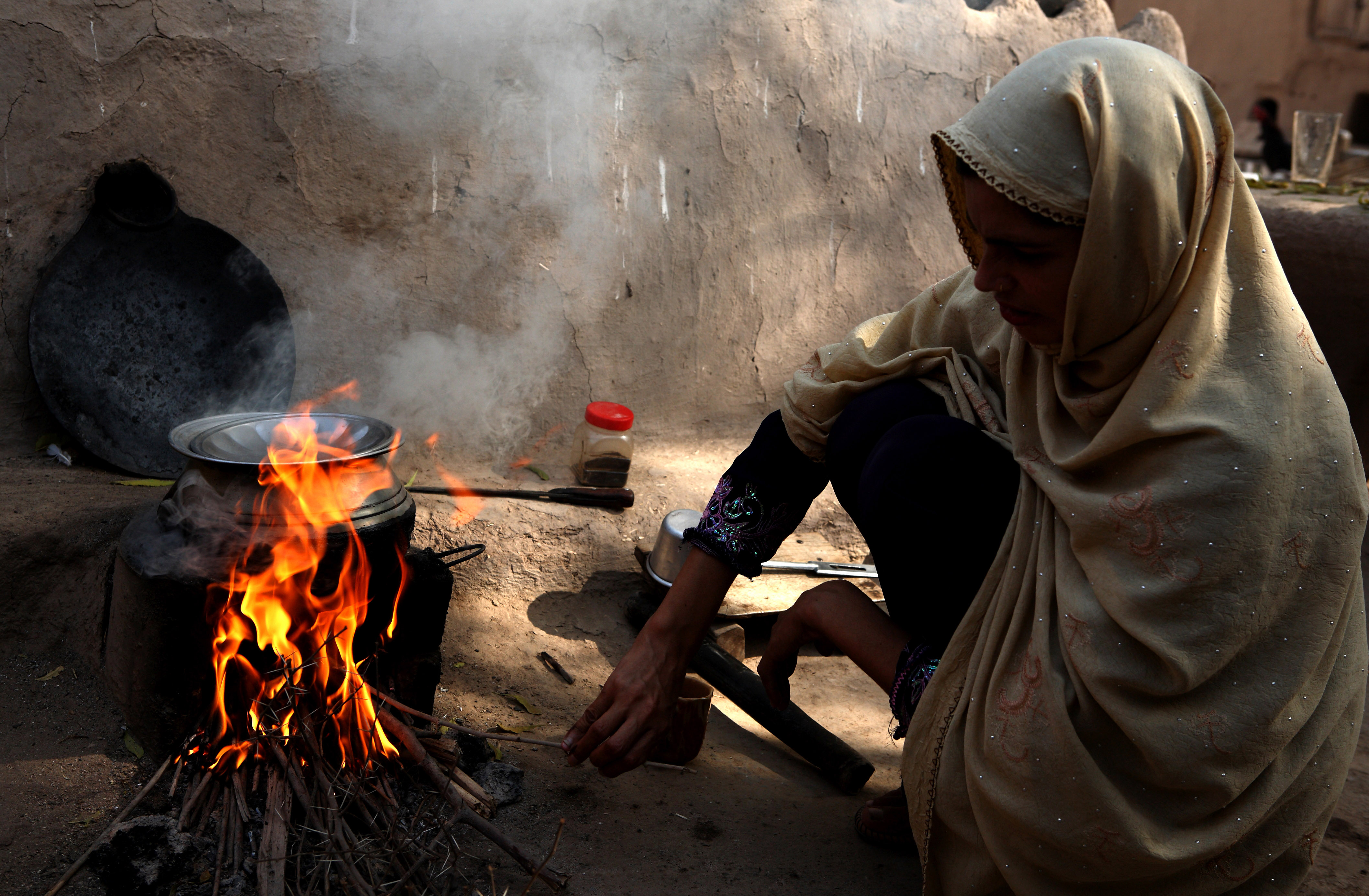 A woman cooking on an open fire